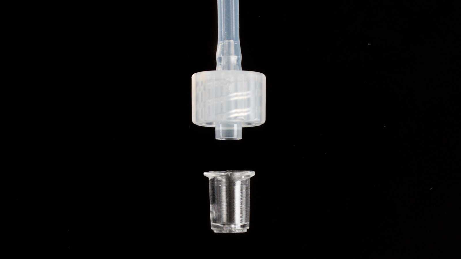 A disassembled Luer-lock interface with the Luer-lock port. From top to bottom: tubing, plug, and the Luer-lock port.
