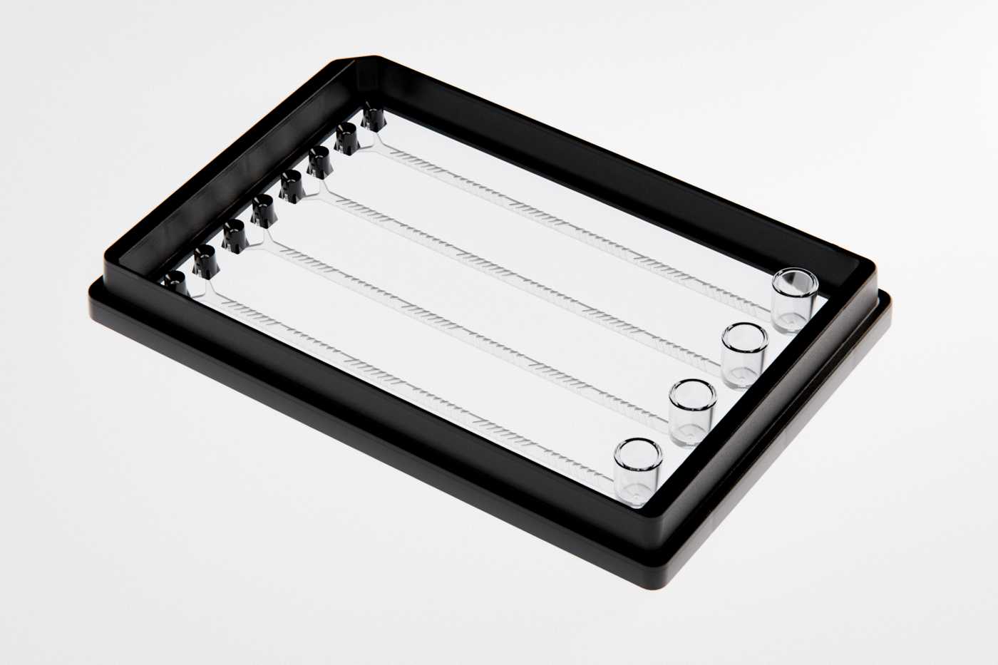 A SLAS format microfluidic device with four sets of identical channels. Each channel has two pipette interfaces on one end and a reservoir on the other end. Herringbone mixers occupy the majority of each channel’s length.