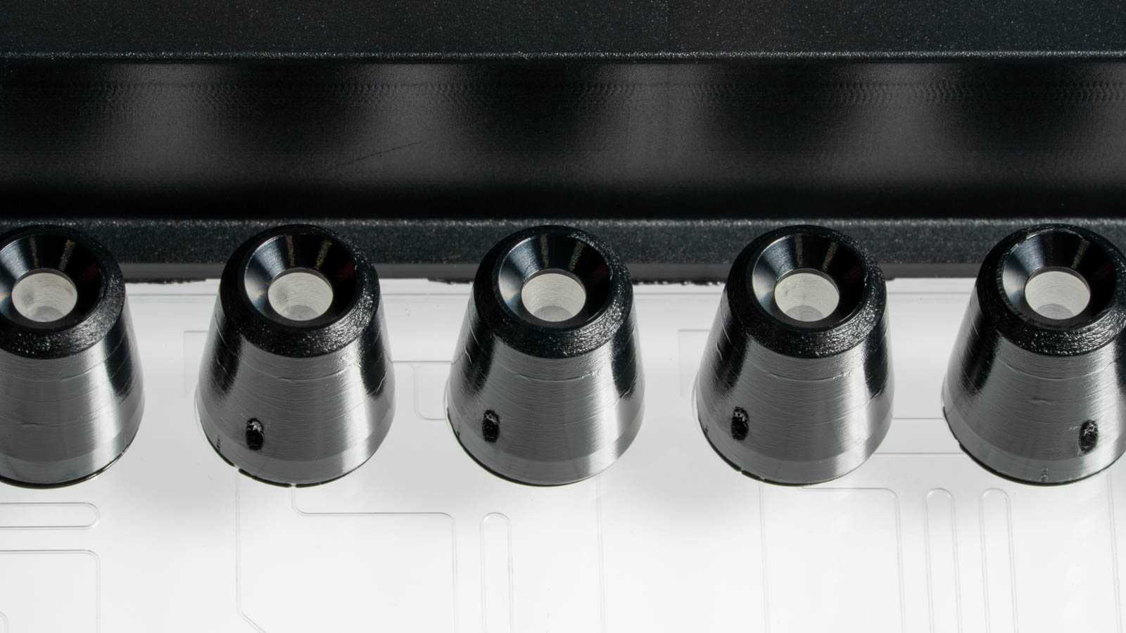 Close-up of a pipette interface on a SLAS format microfluidics device. The pipette interface is of a tapered conical shape, and has an opening at the top.