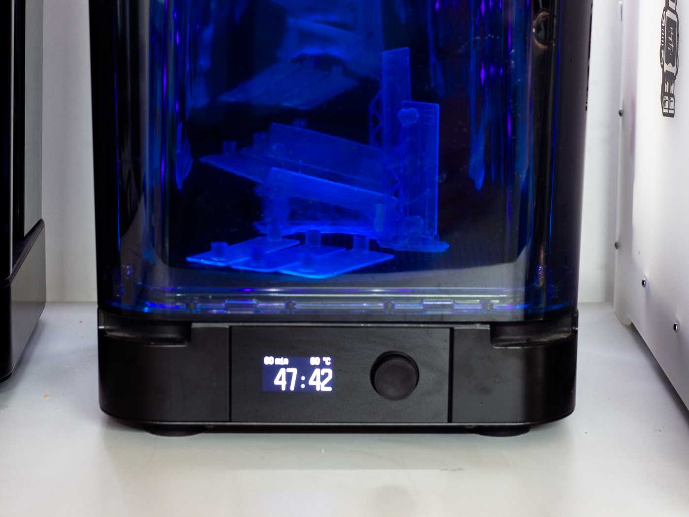 A SLA UV curing oven with multiple microfluidic devices visible through its transparent blue shell.