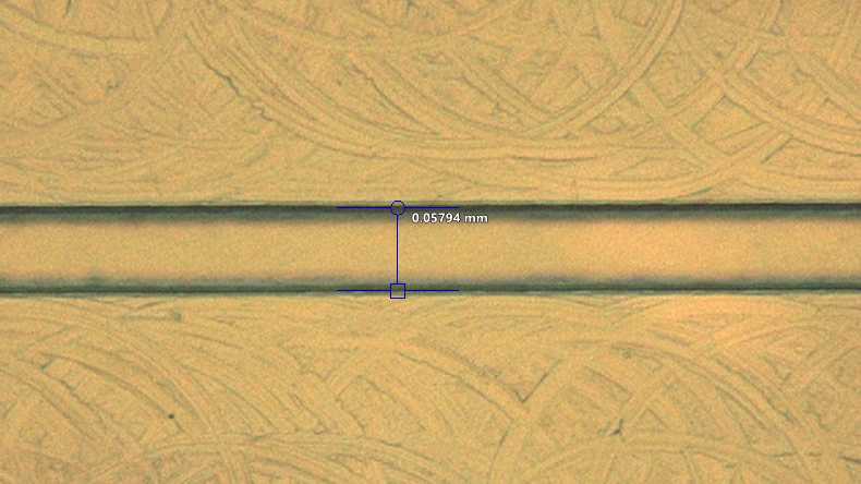 Close-up of a Transition Molded microfluidic channel that measures 0.05794 millimeters in width at the center. The channel is clearly defined with clean edges.
