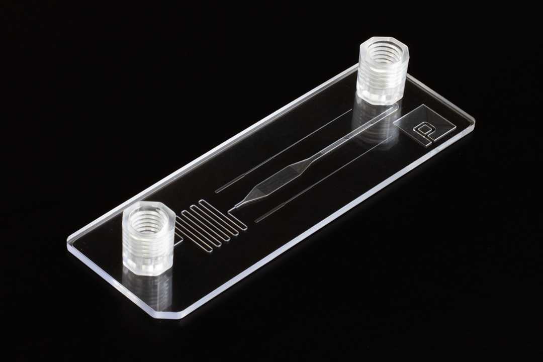A slide format microfluidic device that is Transition Molded. The device is transparent with smooth surfaces. Smaller features are distinct and clear.
